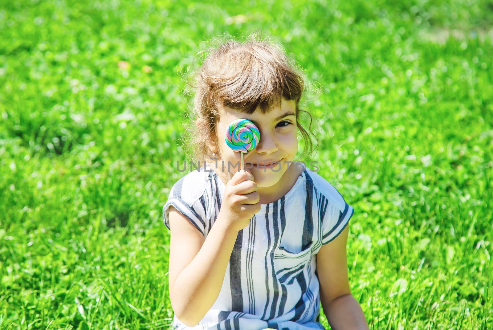 child eats lollipop on nature. Selective focus.