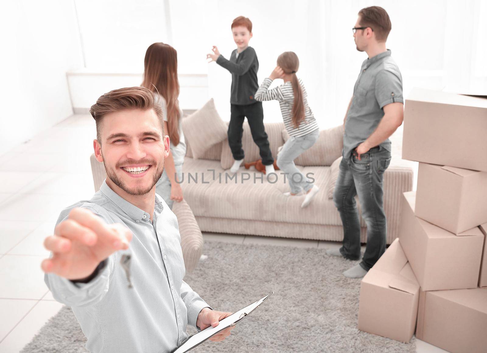 smiling realtor with clipboard showing keys to new apartment.mortgage, family and real estate concept