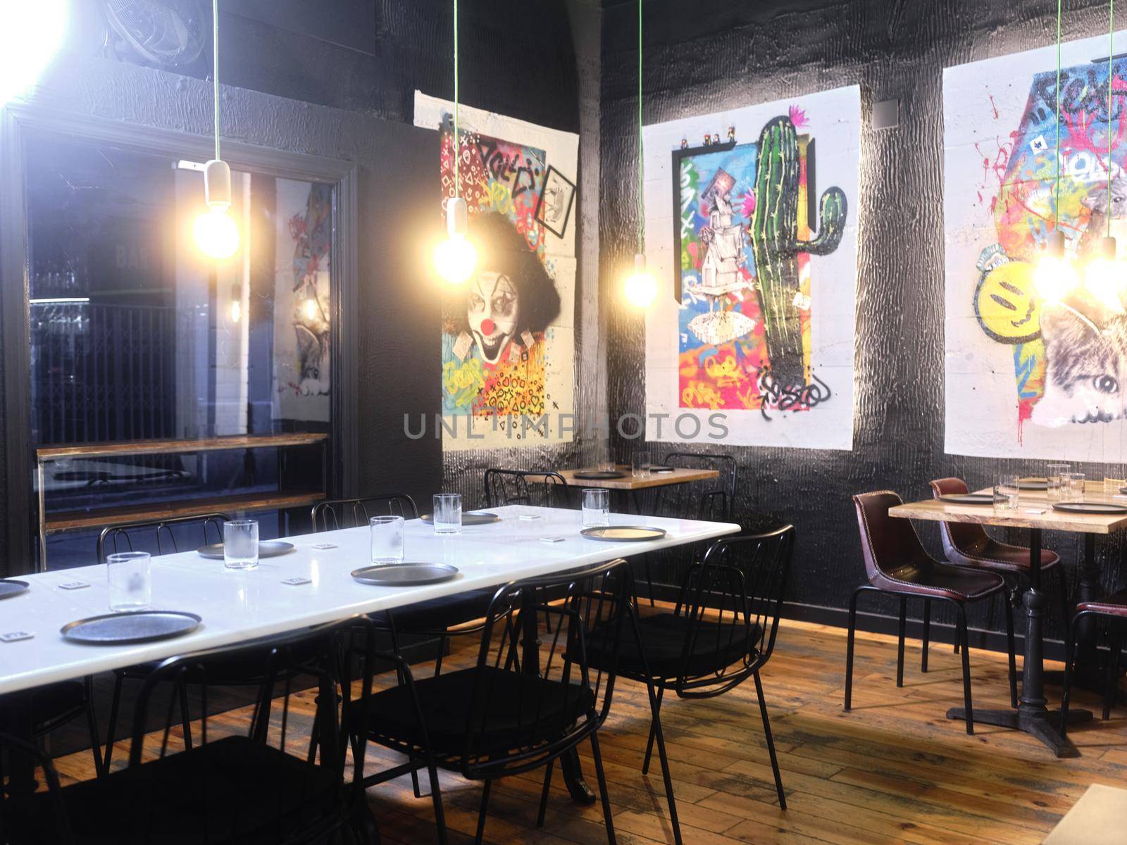 Interior of a modern restaurant decorated with paintings with graffiti on the walls