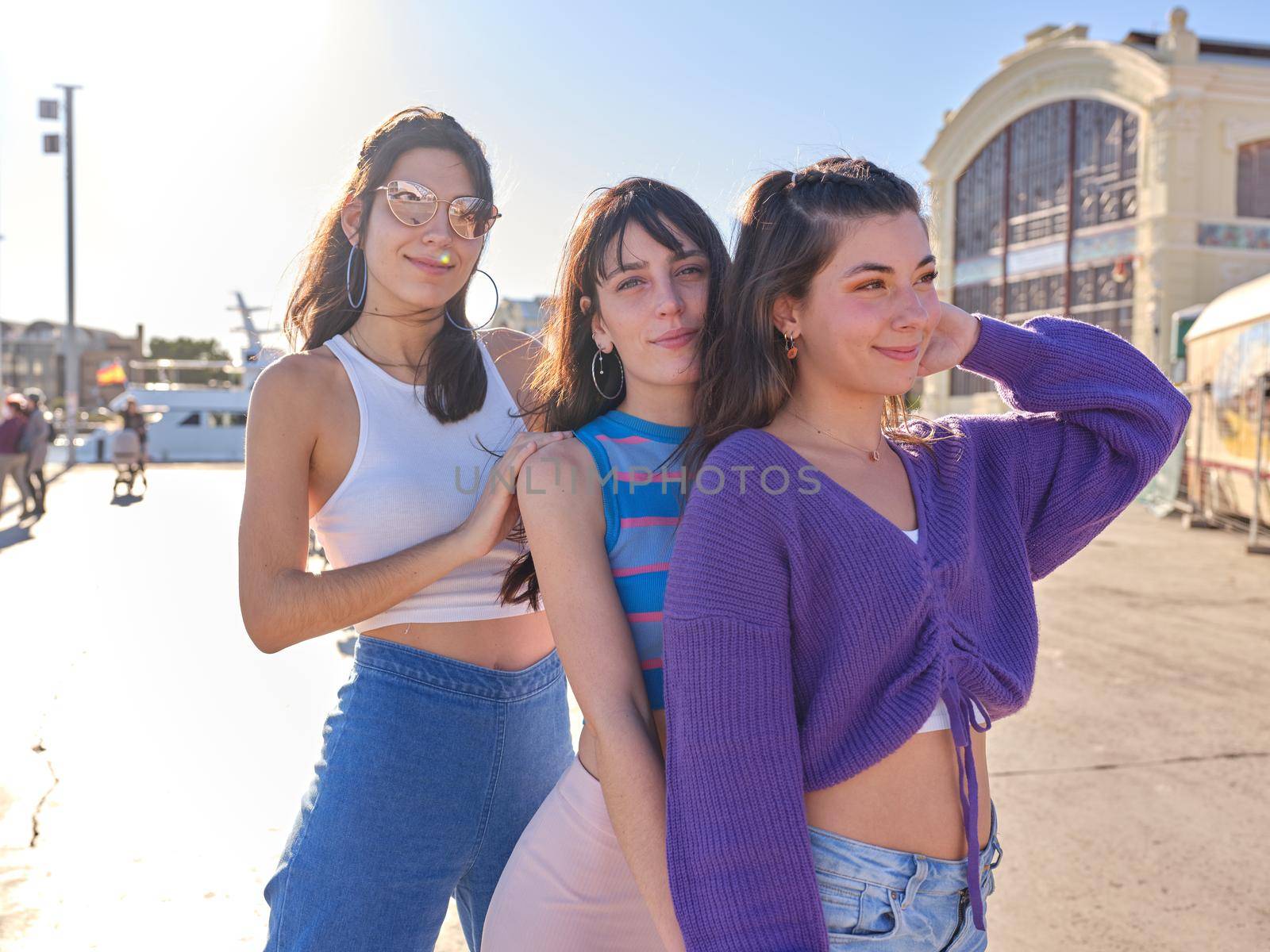 Three beauty women with vintage style standing together on a pier on a sunny day of summer