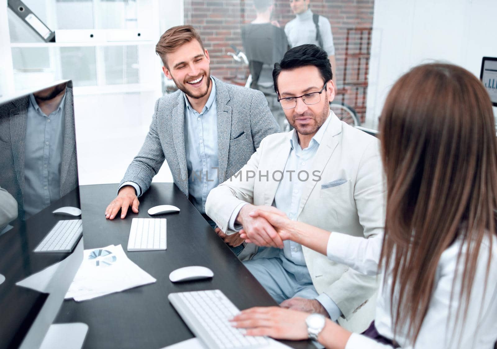 smiling colleagues sitting at the Desk by asdf