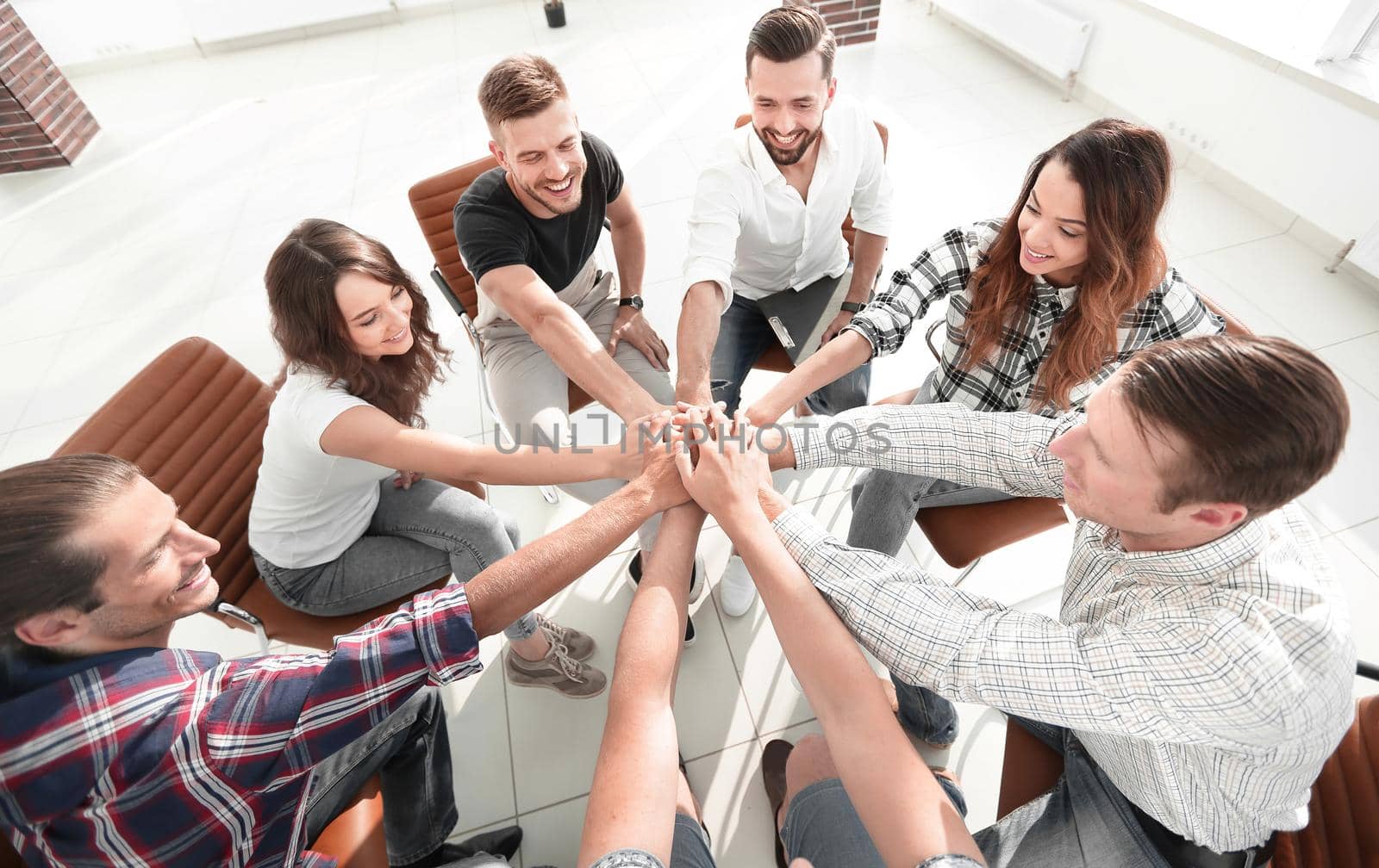 successful business team sitting in the middle of the office and hands clasped together