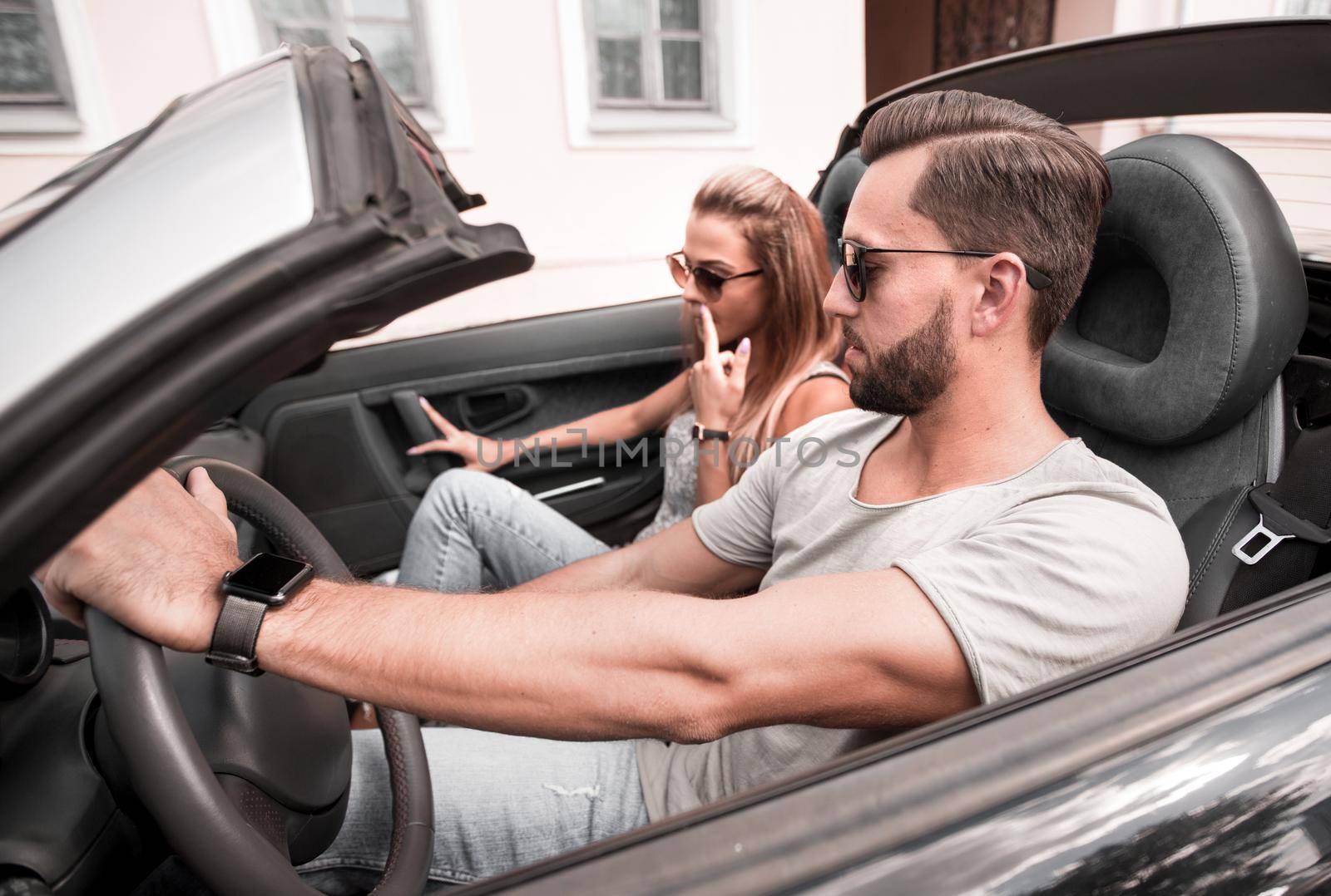 loving couple driving in a convertible on a city street.urban lifestyle