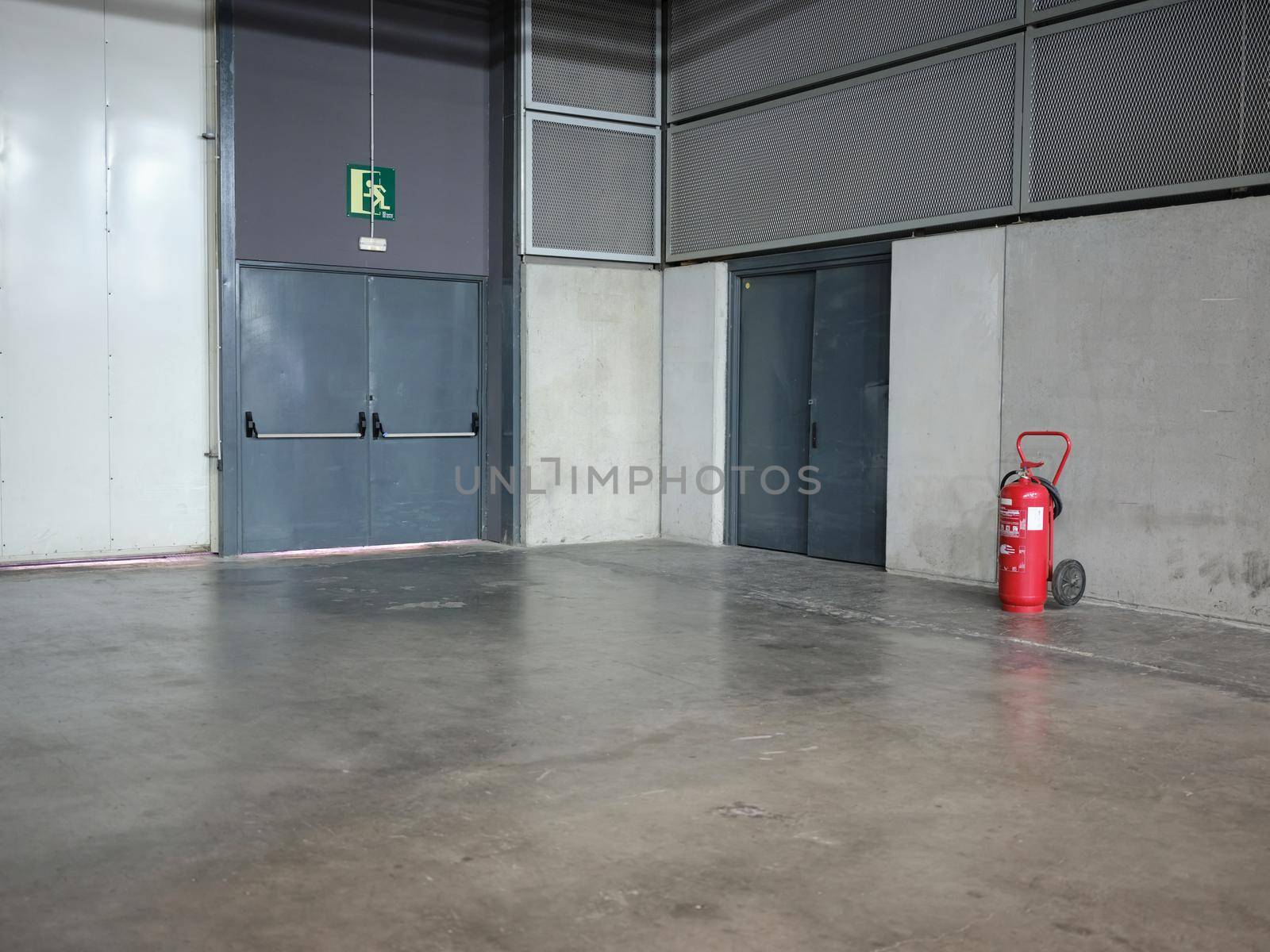 Emergency exit doors of an industrial area with a fire extinguisher by WesternExoticStockers