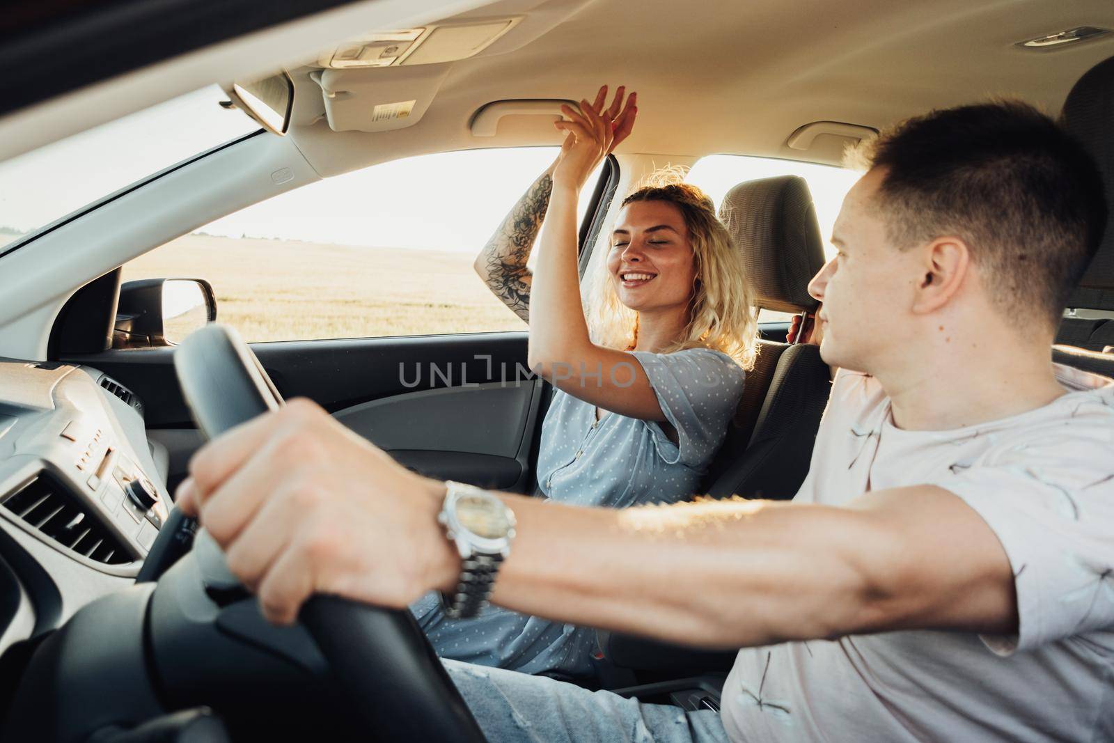 Happy Couple Enjoying Road Trip, Young Caucasian Woman and Man Having Fun Time While Traveling by Car by Romvy