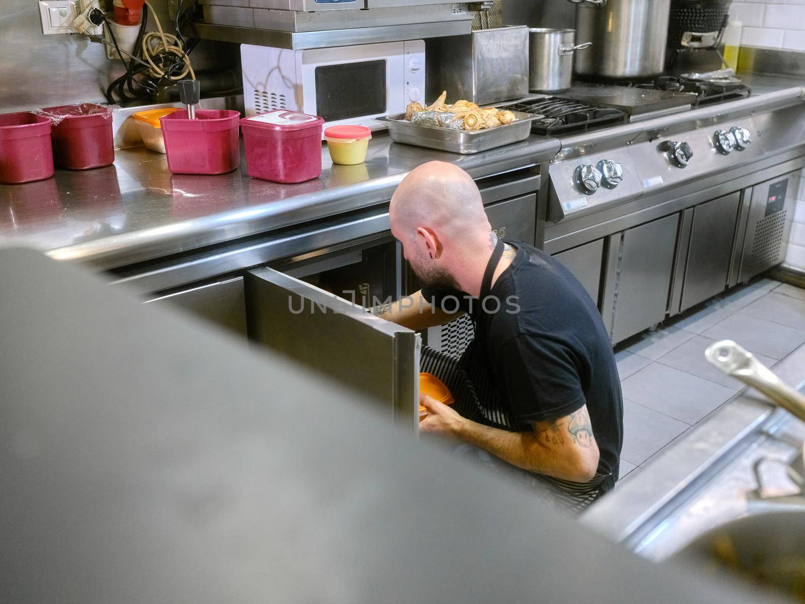 Cook storing food in stainless steel kitchen fridges by WesternExoticStockers