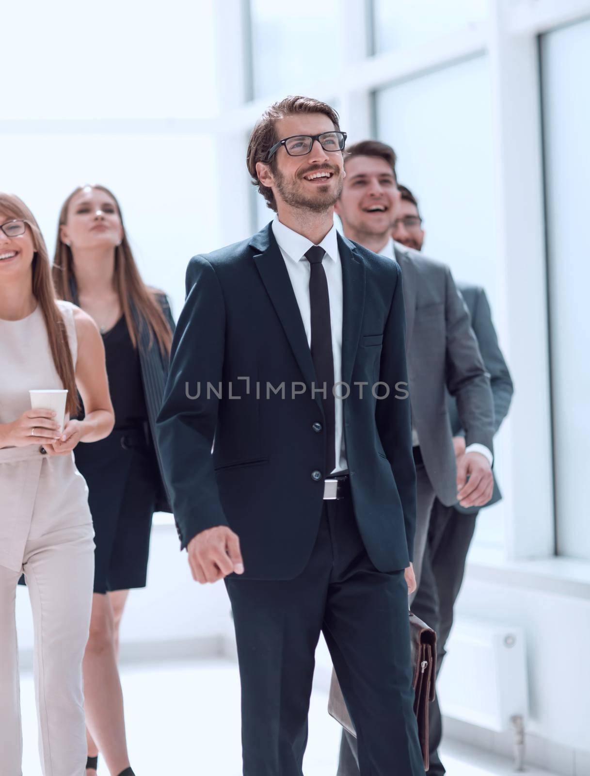 businessman walking in front of his business team . business concept