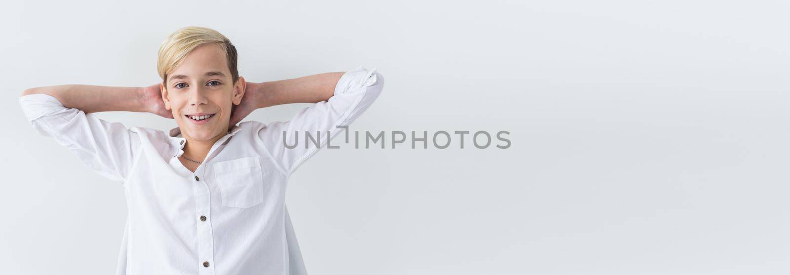 Teen boy happy and smiling with braces on teeth - ortodont dentistry and dental health on white background with copy space banner place for advertising