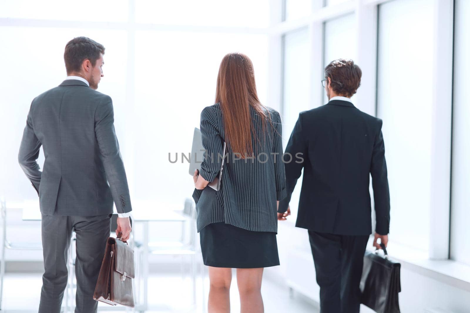 rear view.a group of business people walking down the office corridor . business concept