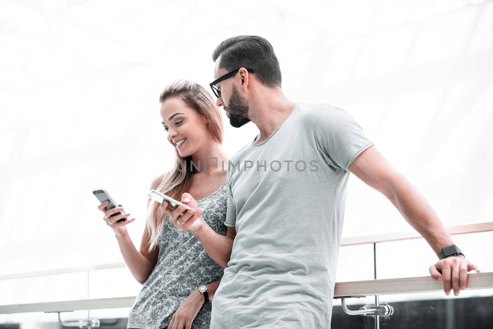 young couple reading text message on smartphone by asdf
