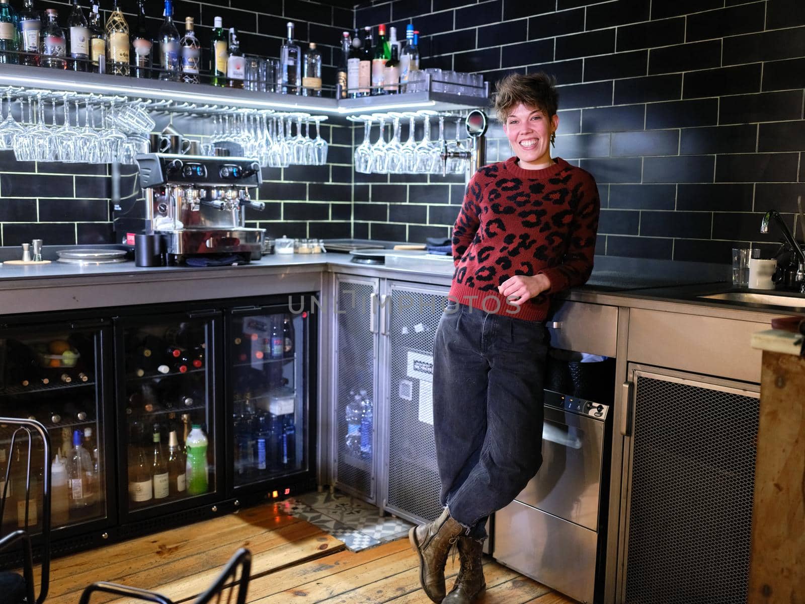 Portrait of a female manager with a modern style and sort hair posing standing on the restaurant