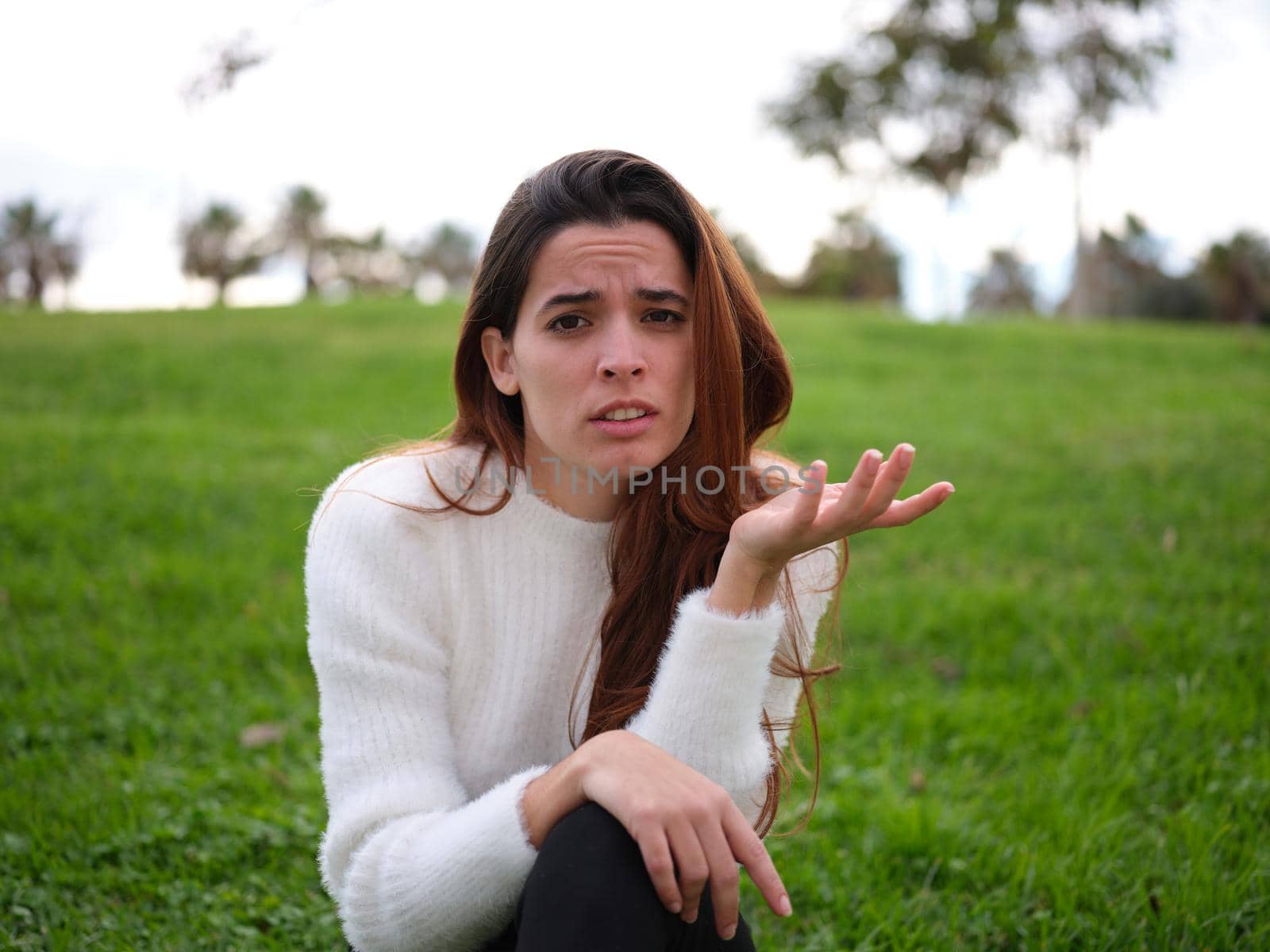 Front view of a portrait of an upset woman raising an eyebrow and her hand. Concept of emotions.