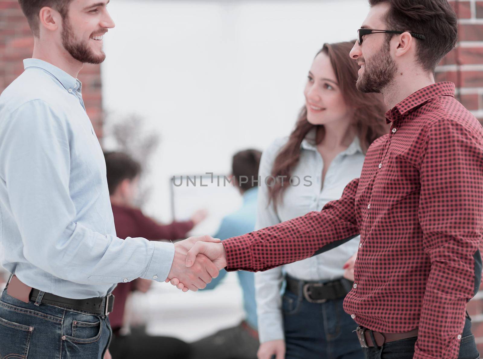 Handshake between businesspeople in a modern office.