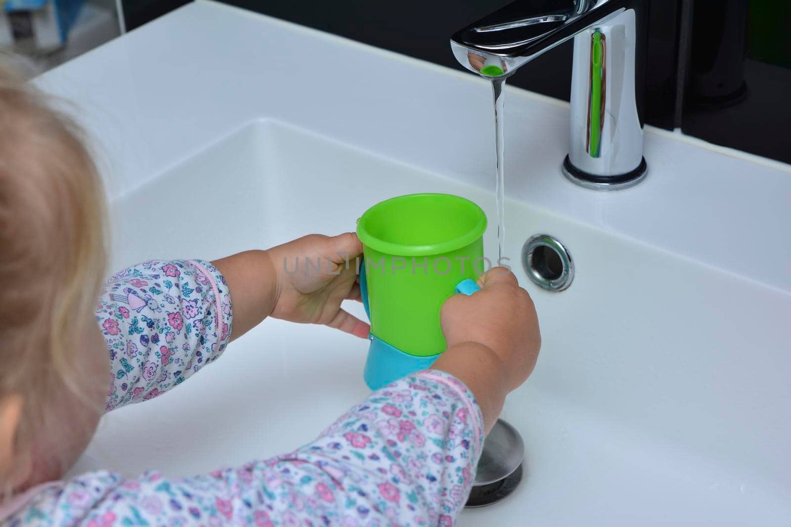 Girl holding a glass in her hands and pouring water