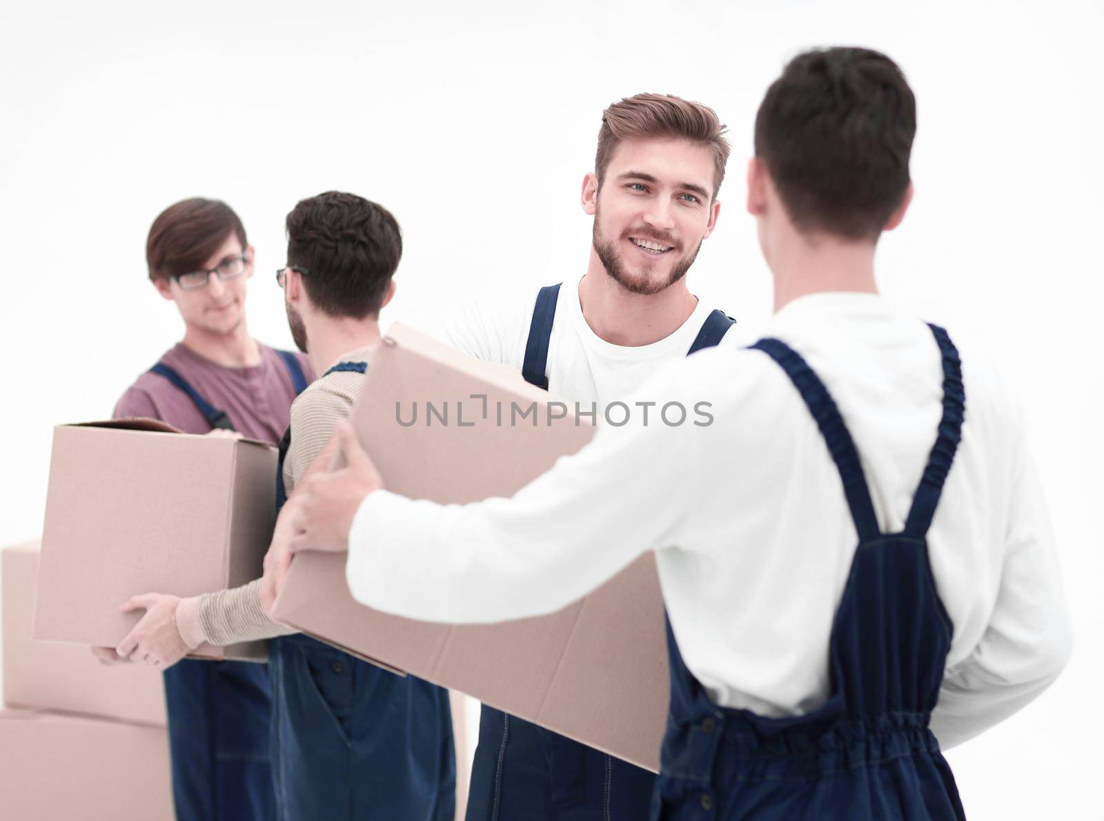 Movers lifting stack of cardboard moving boxes isolated on white