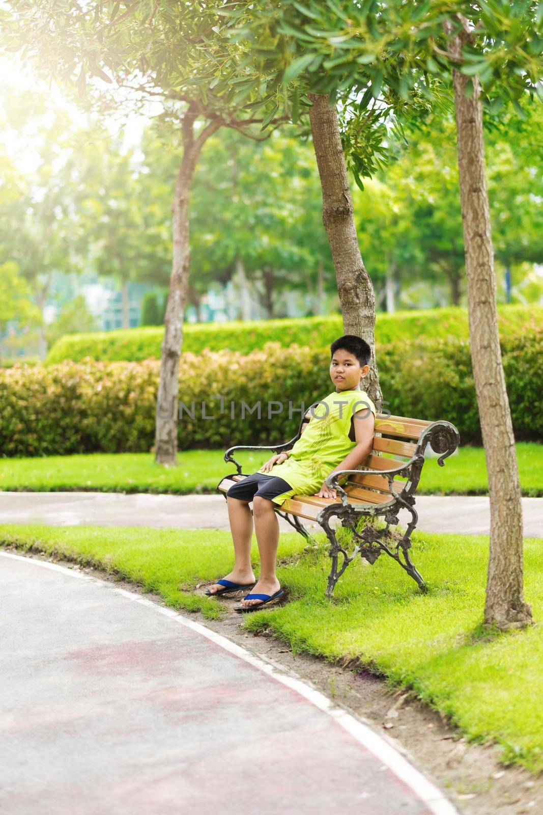 Sport concept - Little sport runner boy sit on the track and take a deep breath. Feel tired and bored by Benzoix