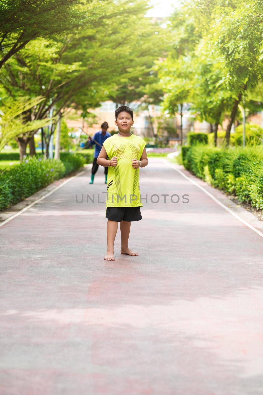 Asian man jogging at the park in sunny morning. by Benzoix
