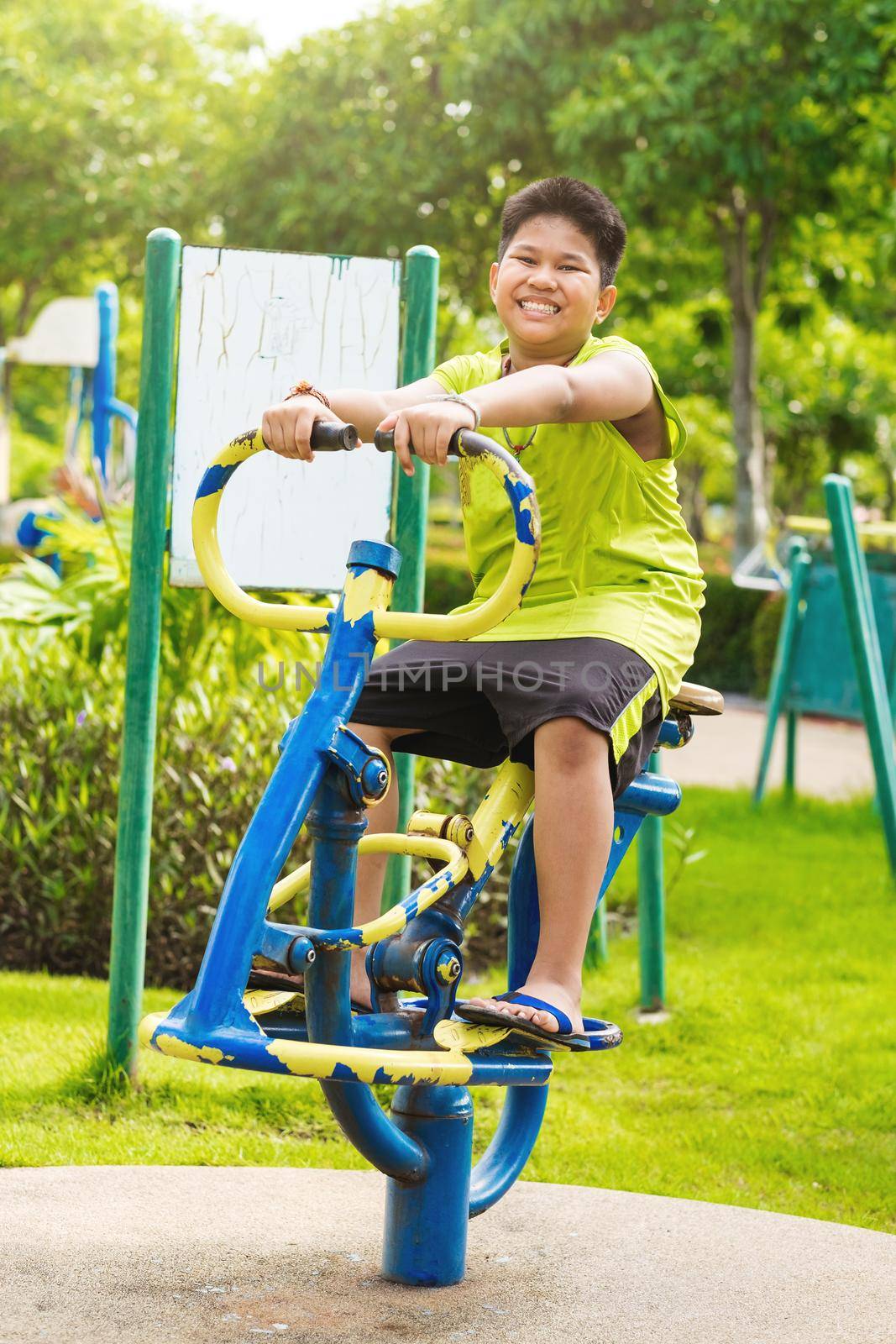 Happy asian sport boy play on swing playground in Garden. by Benzoix