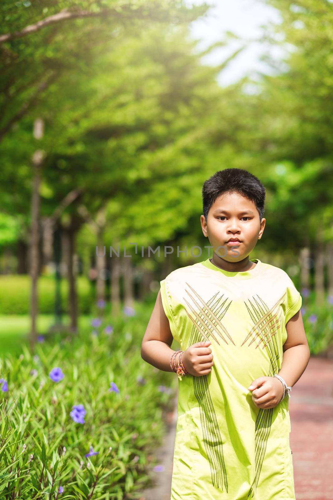 Asian man jogging at the park in sunny morning. by Benzoix