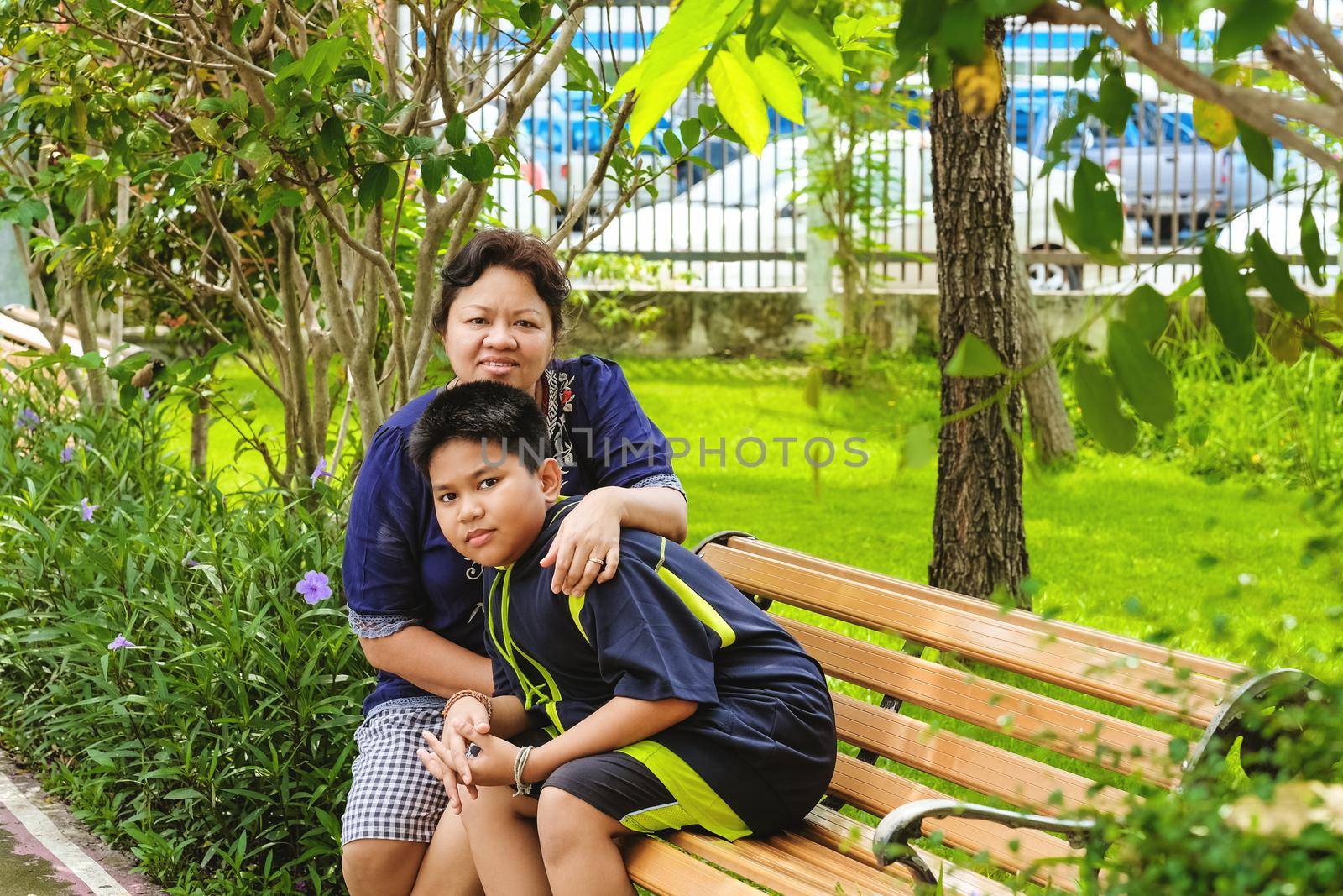 Happy asian woman, mother sitting with her son and sitting in the park.