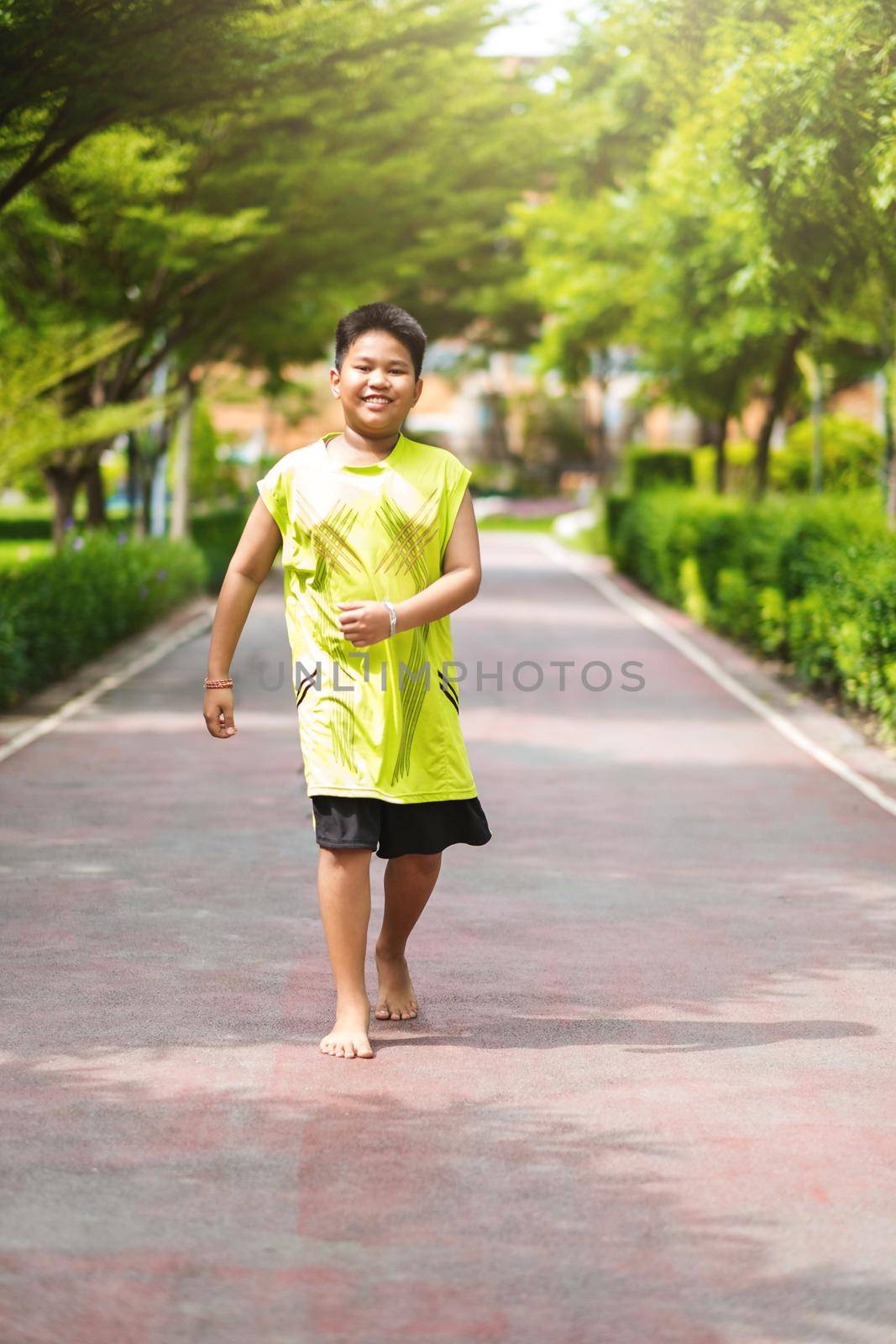 Asian man jogging at the park in sunny morning. by Benzoix