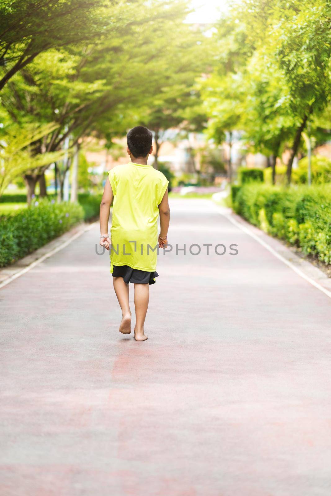 Rare view of young asian boy run in garden