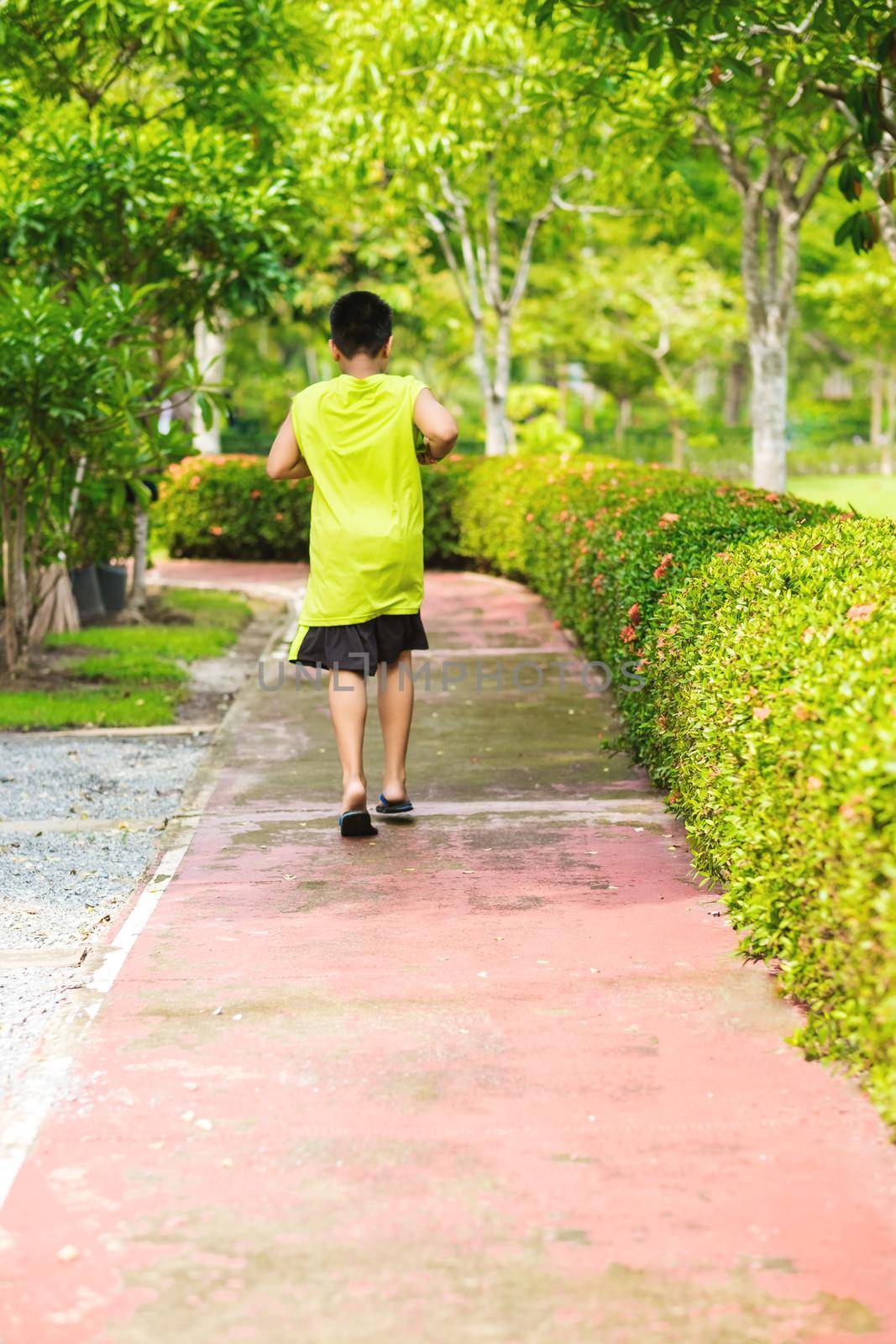 Rare view of young asian boy run in garden
