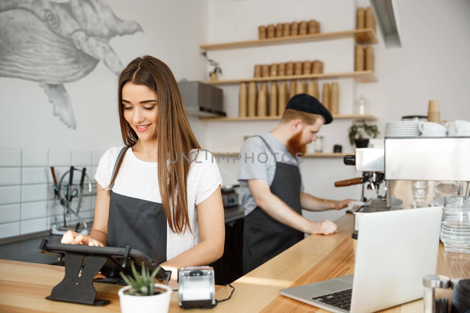 Coffee Business Concept - beautiful caucasian bartender barista or manager Posting order in digital tablet menu at modern coffee shop. by Benzoix