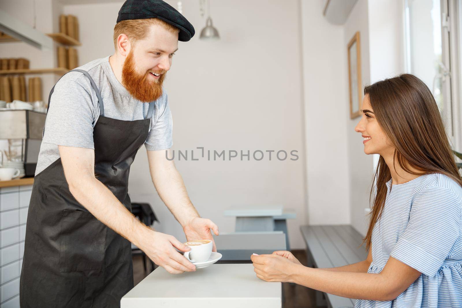 Coffee Business Concept - Waiter or bartender serving hot coffee and talking with caucasian beautiful lady in blue dress at Coffee shop. by Benzoix