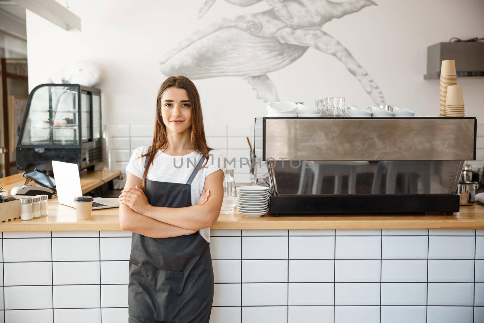 Coffee Business owner Concept - attractive young beautiful caucasian barista in apron smiling at camera in coffee shop counter.