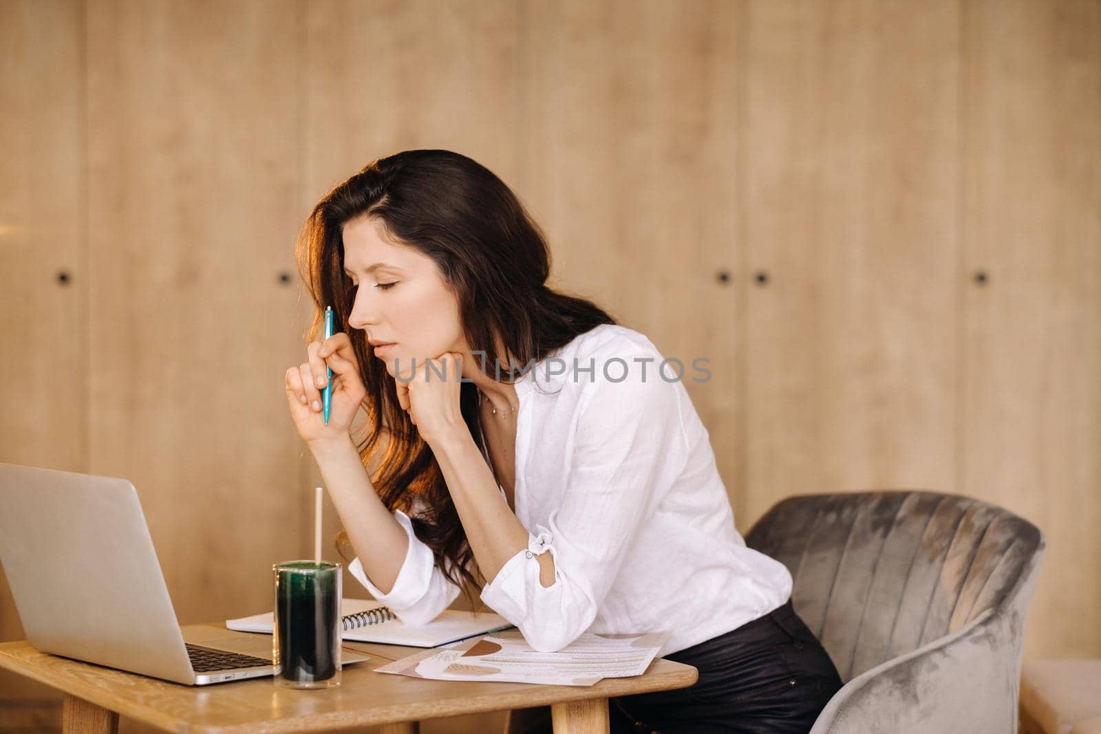 The girl is sitting at a desk in the office and working.