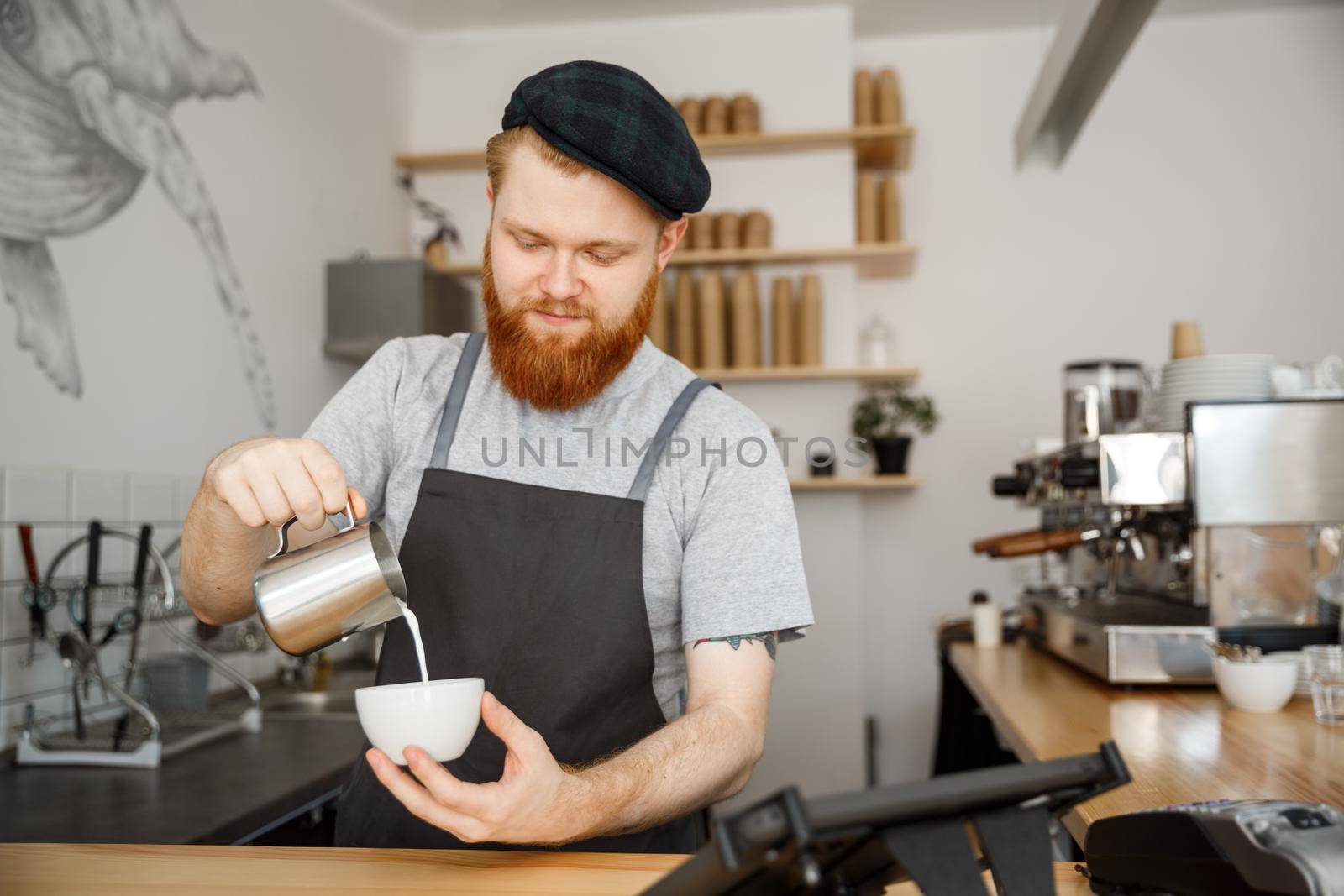 Coffee Business Concept - handsome bearded man in apron making coffee while standing at cafe
