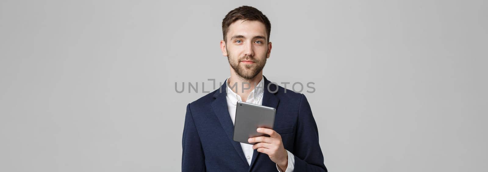 Business Concept - Portrait Handsome Business man playing digital tablet with smiling confident face. White Background. Copy Space. by Benzoix