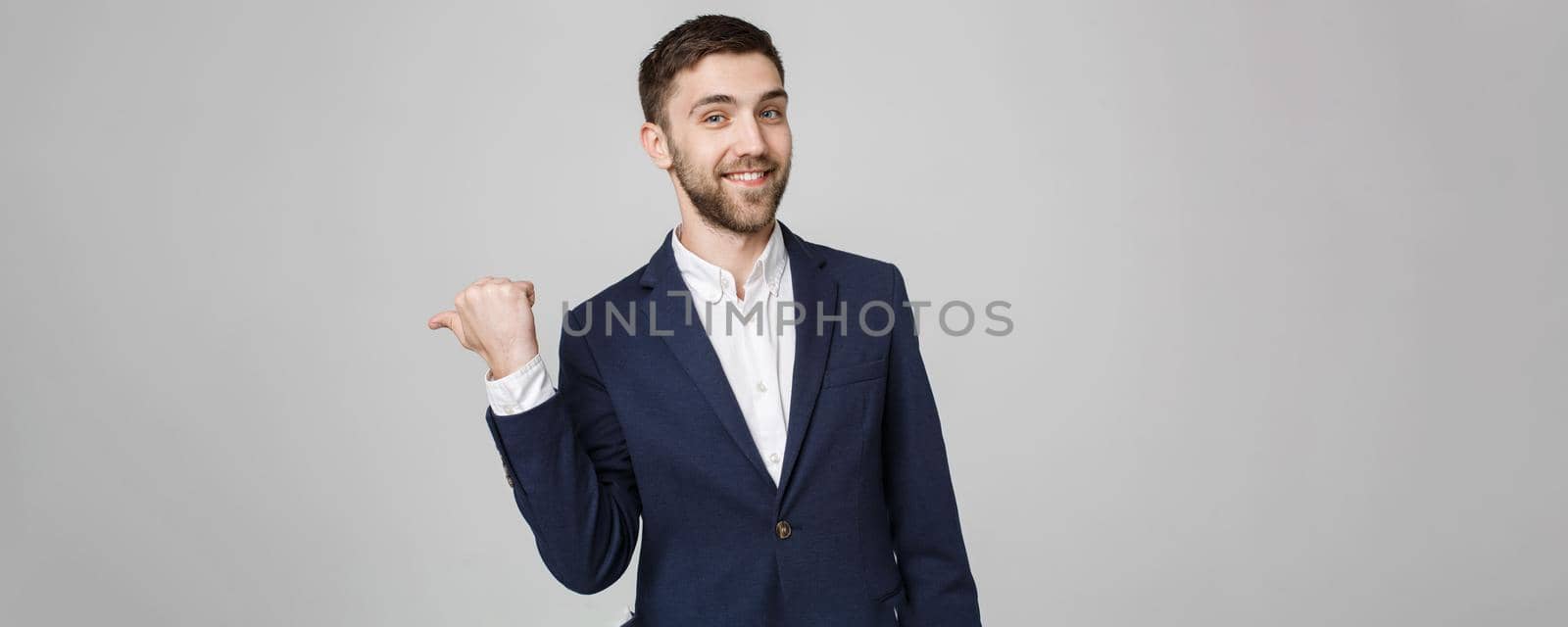 Business Concept - portrait young successful businessman pointing finger over dark background. Copy space. by Benzoix