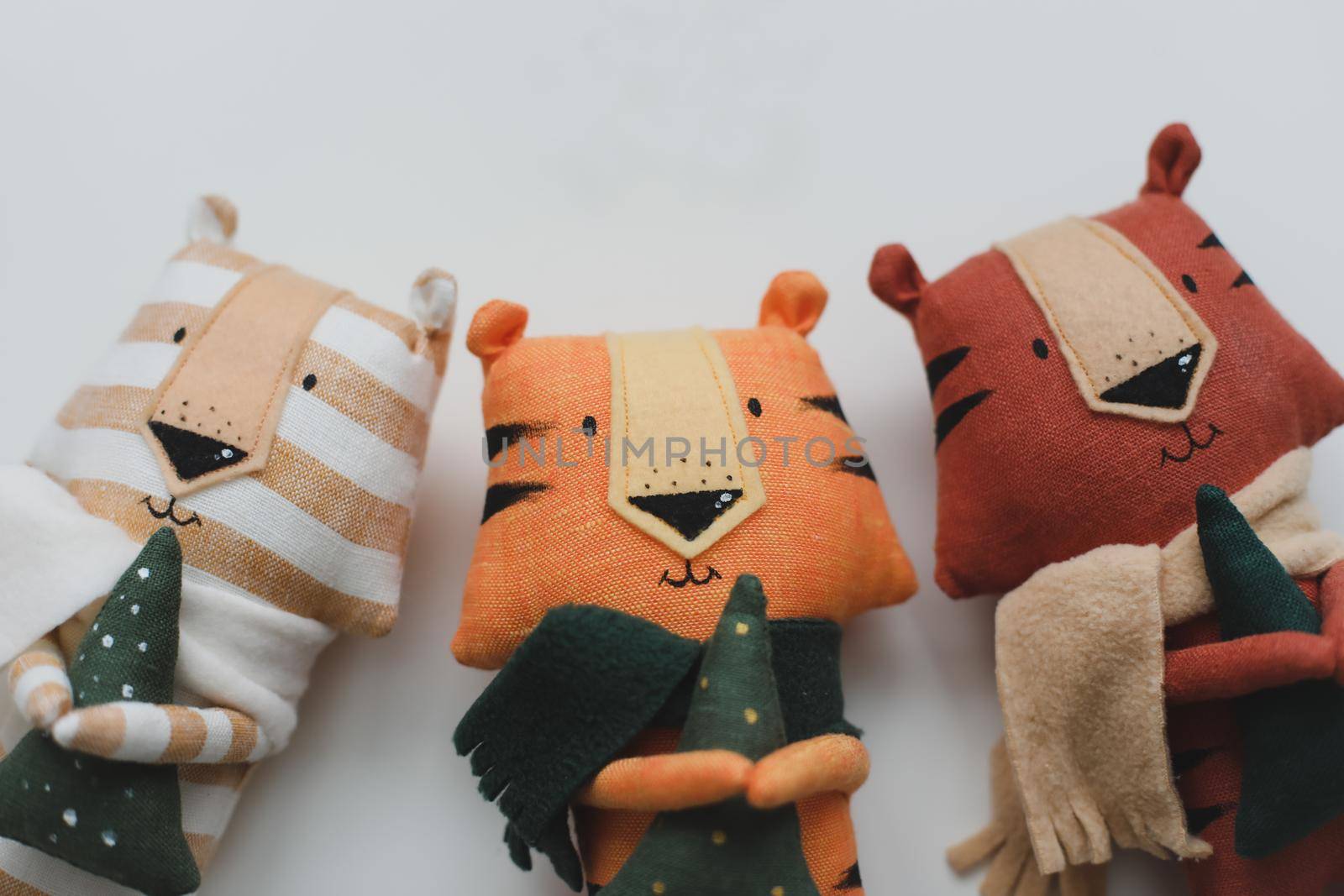 Handmade funny small tiger toys, symbol of new 2022 on white background. Crochet stuffed animals.