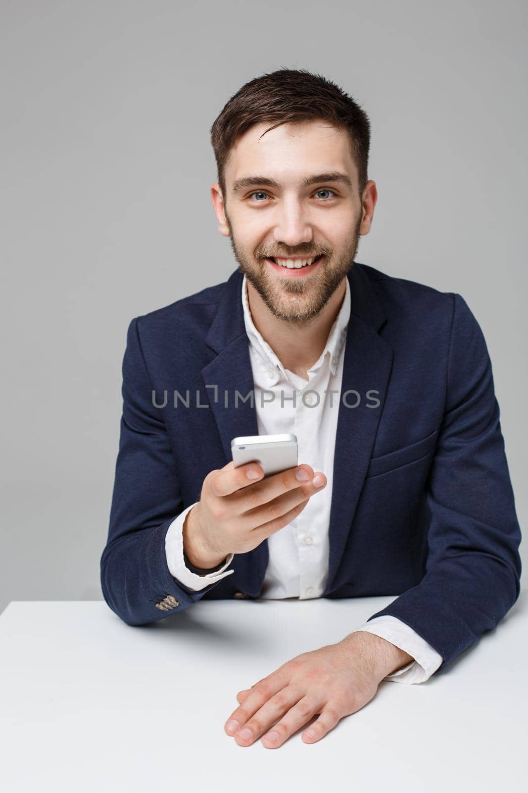 Business Concept - Portrait Handsome Business man playing phone with smiling confident face. White Background.Copy Space. by Benzoix
