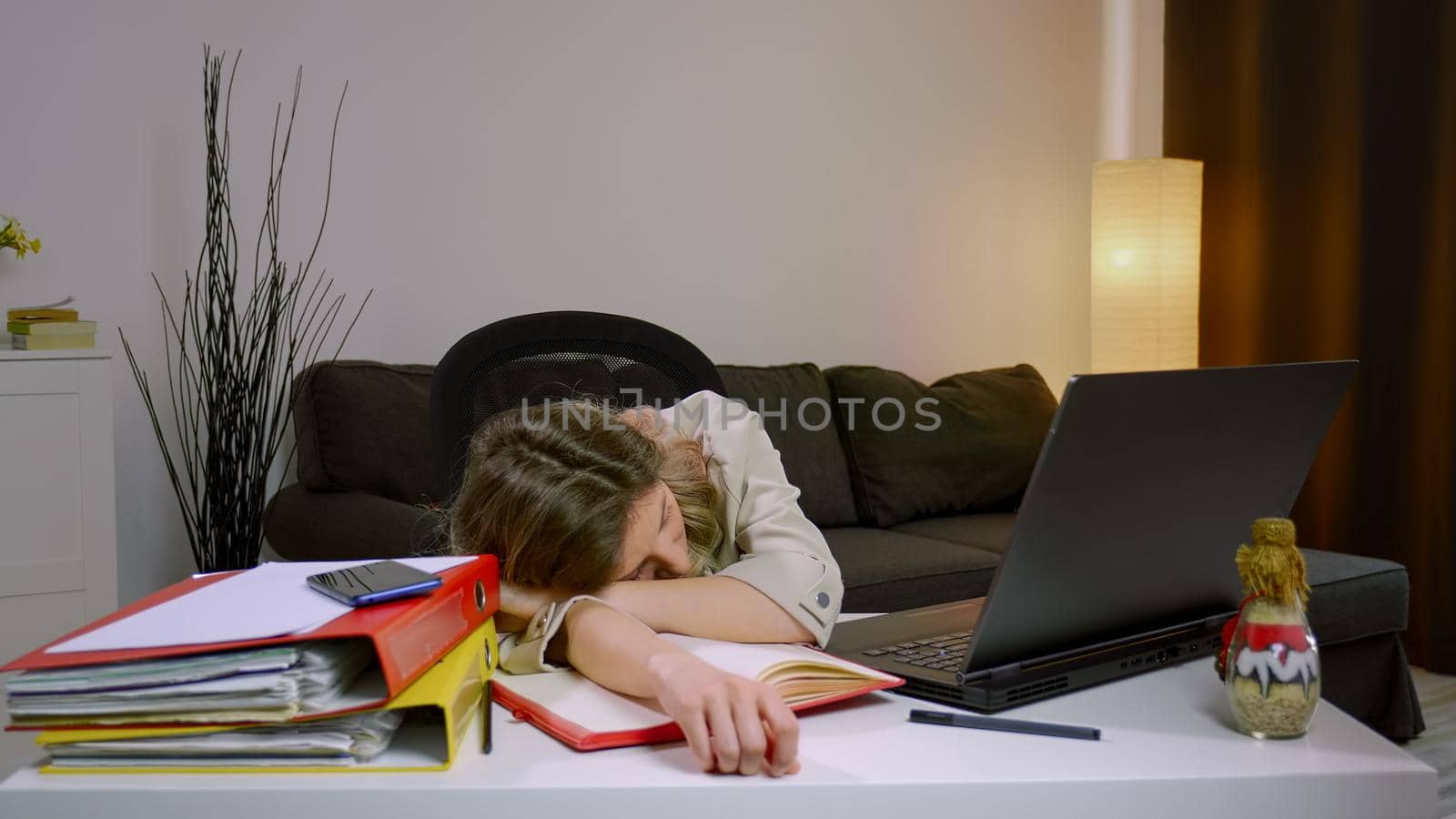 Tired stressed overworked Caucasian business woman falling asleep at desk, sitting at table with laptop. Depressed unmotivated freelancer lying on table,