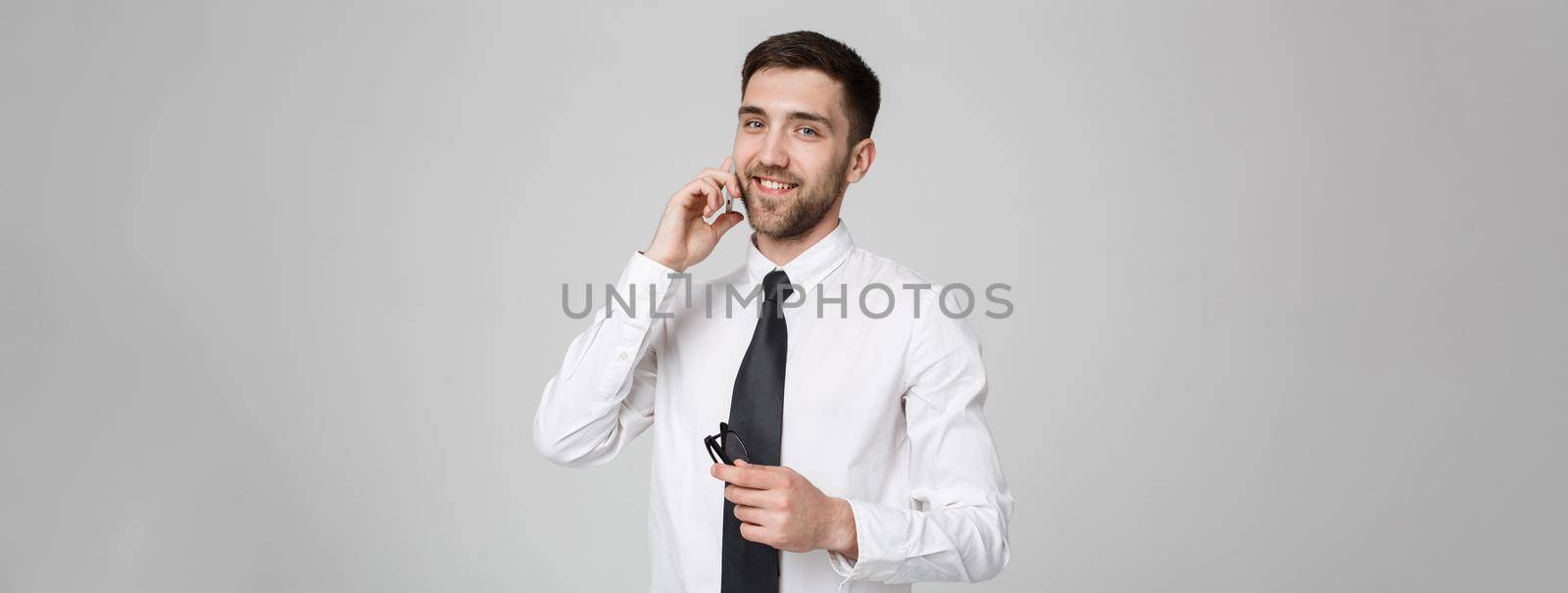 Lifestyle and Business Concept - Portrait of a handsome businessman enjoy talking with mobile phone. Isolated White background. Copy Space. by Benzoix