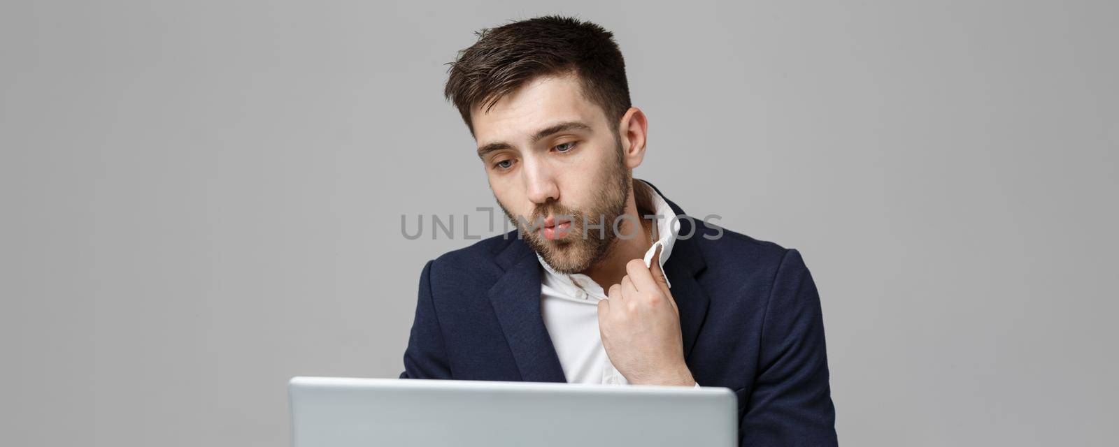 Business Concept - Portrait handsome stressful business man in suit shock looking at work in laptop. White Background. by Benzoix