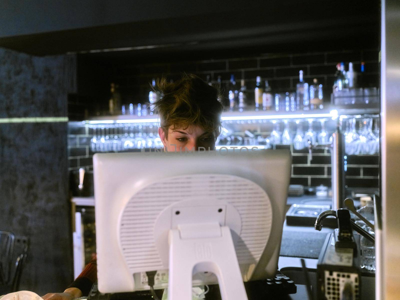 Restaurant manager working at the reception desk using a computer by WesternExoticStockers