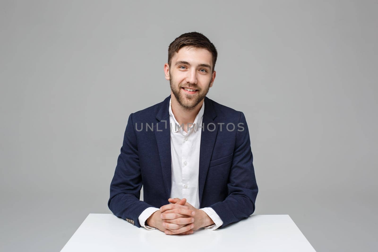 Business Concept - Portrait handsome happy handsome business man in suit smiling and siting in work office. White Background.