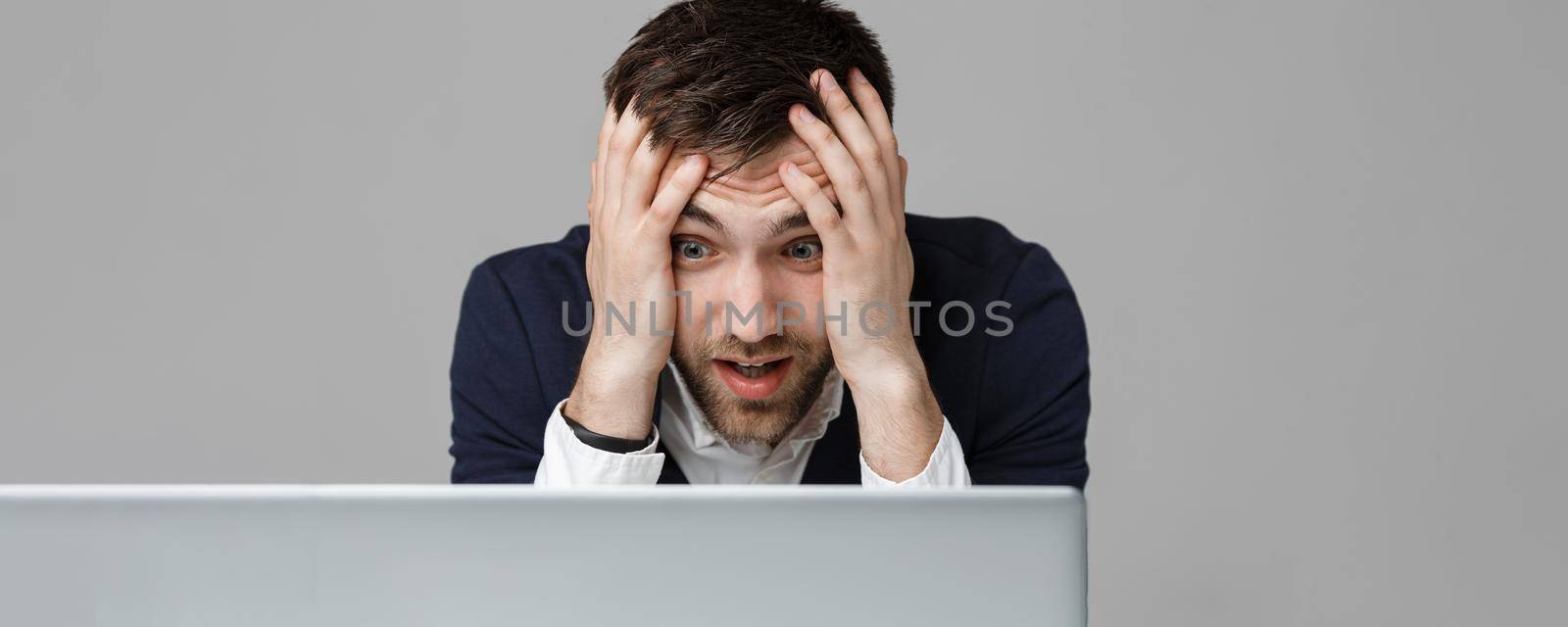 Business Concept - Portrait handsome stressful business man in suit shock looking at work in laptop. White Background.