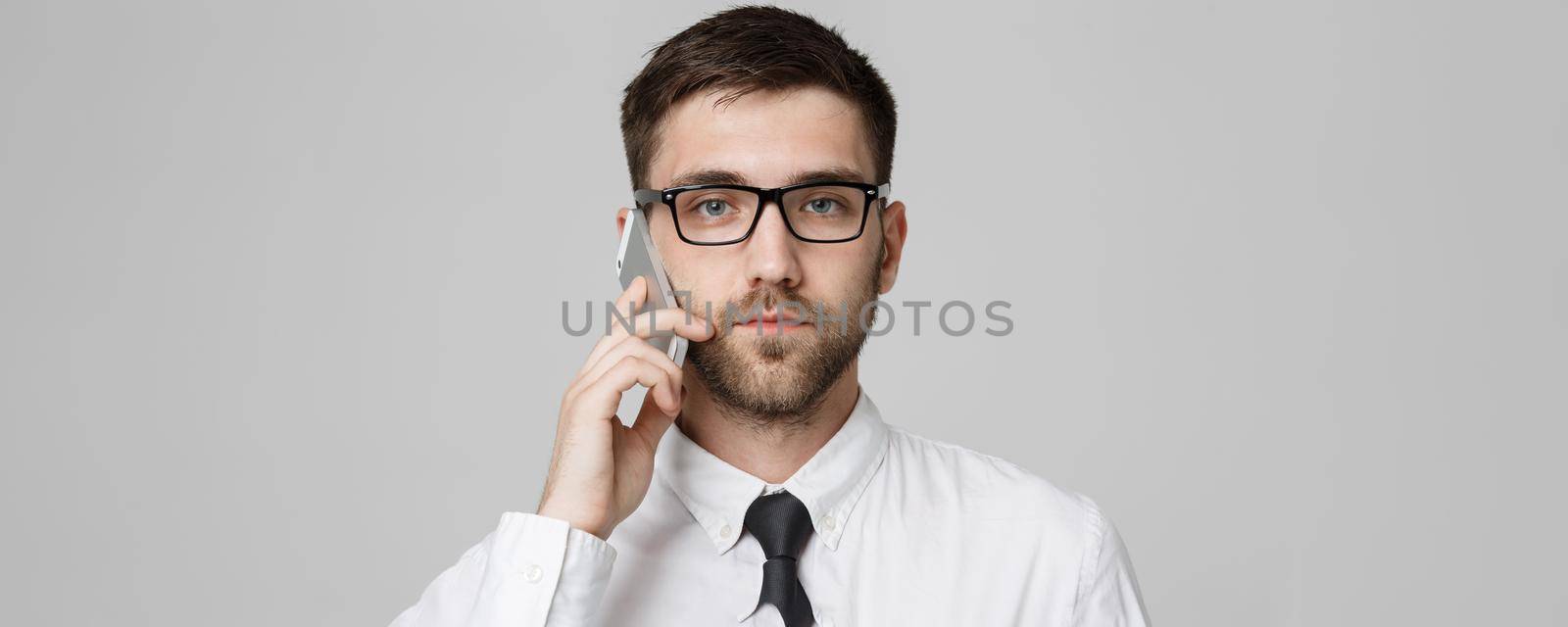 Lifestyle and Business Concept - Portrait of a handsome businessman serious talking with mobile phone. Isolated White background. Copy Space. by Benzoix