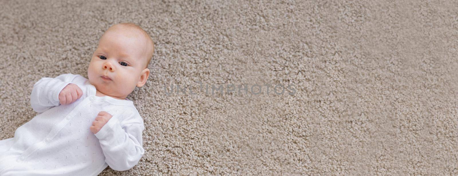 Childhood, infant and people concept - small baby lying on floor banner with copy space and place for advertising by Satura86