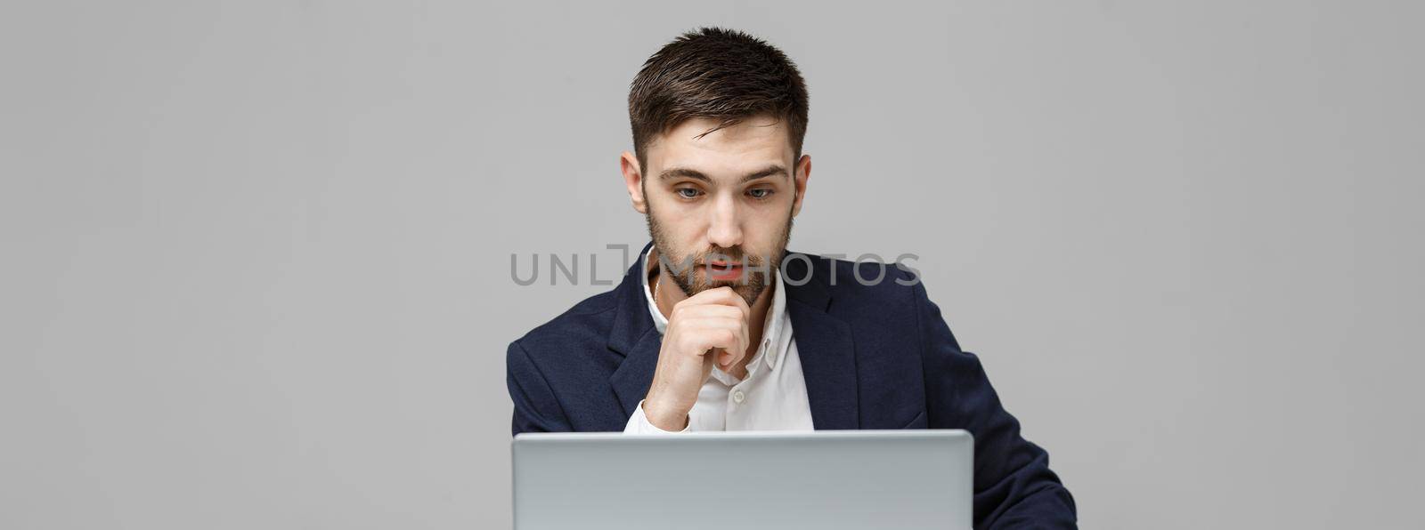 Business Concept - Portrait handsome stressful business man in suit shock looking in front of laptop at work office. White Background. by Benzoix