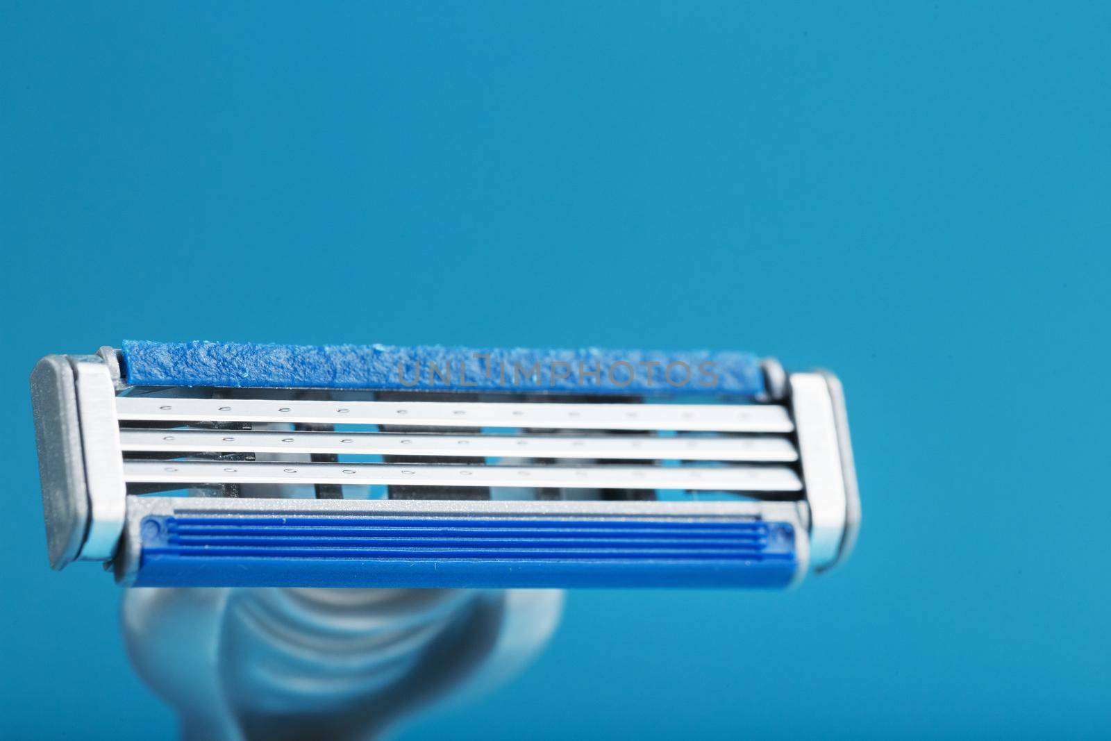 Shaving machine with three blades on a blue background close-up free space