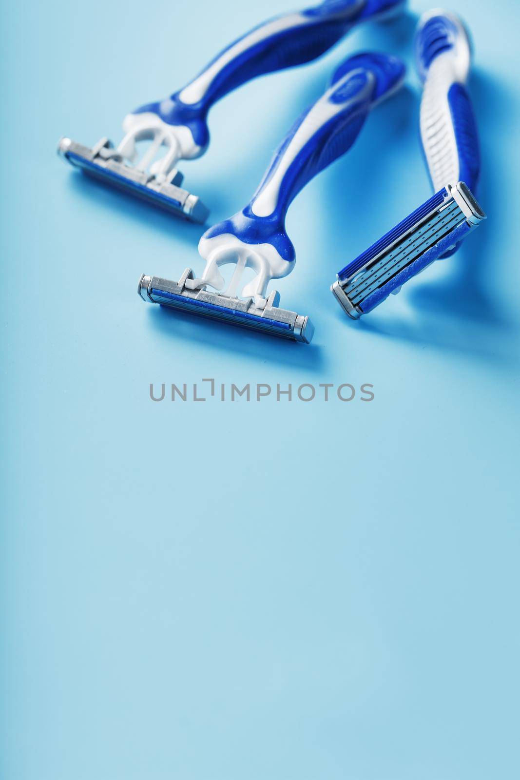 Blue shaving machines in a row on a blue background by AlexGrec