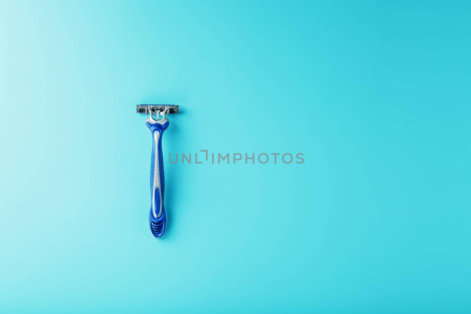 Shaving machine for the face on a blue background top view free space by AlexGrec
