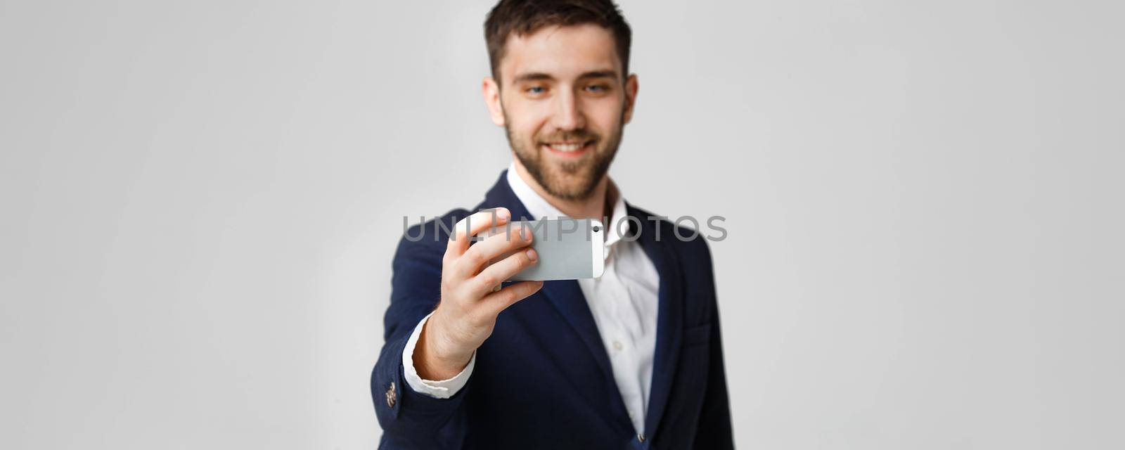 Business Concept - Handsome Business man take a selfie of himself with smartphone. White Background.