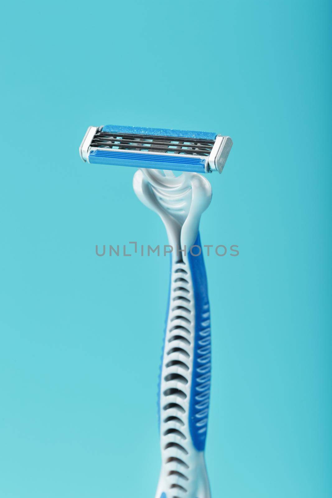 Blades of a new shaving machine on a blue background by AlexGrec